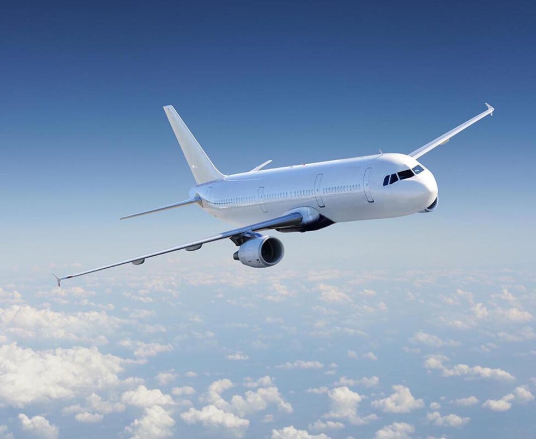 Airplane in the sky, over the cloudy sky